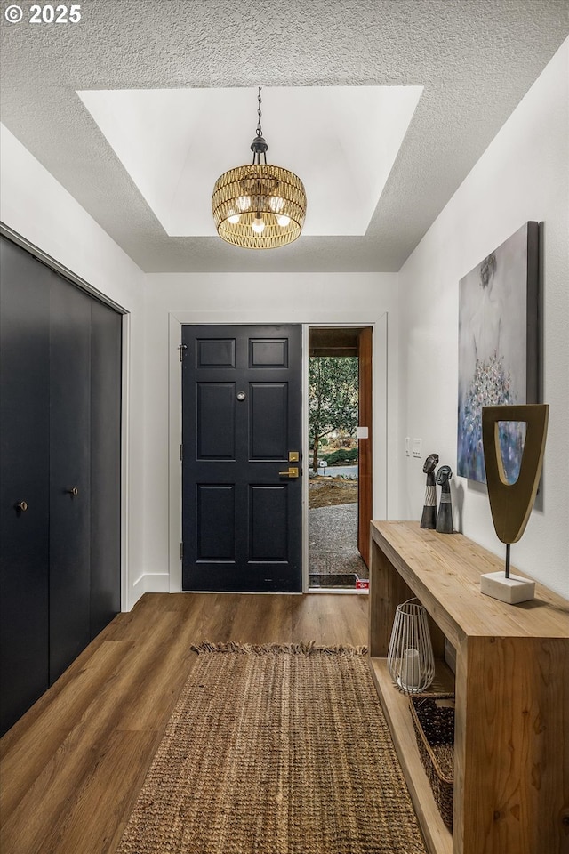 foyer featuring a textured ceiling, hardwood / wood-style floors, and a tray ceiling