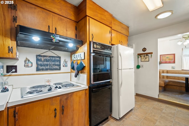 kitchen with freestanding refrigerator, under cabinet range hood, stainless steel electric stovetop, and brown cabinetry