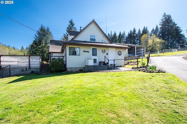rear view of property featuring asphalt driveway