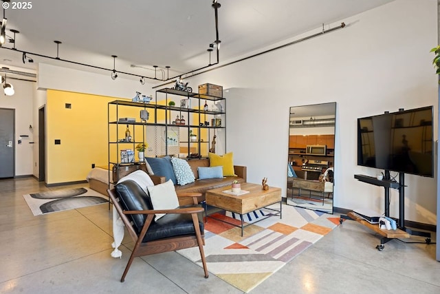 living area with concrete floors and baseboards