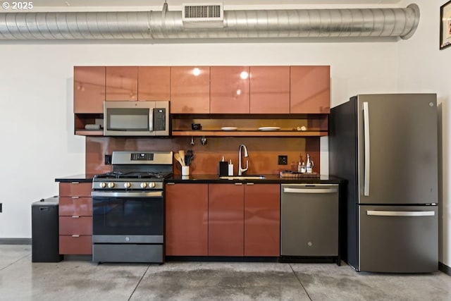 kitchen featuring visible vents, dark countertops, stainless steel appliances, open shelves, and a sink