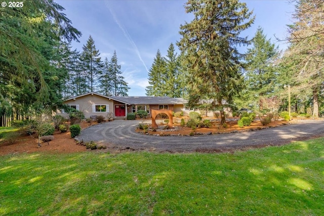 ranch-style house with a front yard and curved driveway