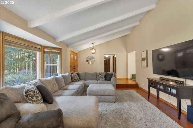 living room with baseboards, lofted ceiling with beams, wood finished floors, and a textured ceiling
