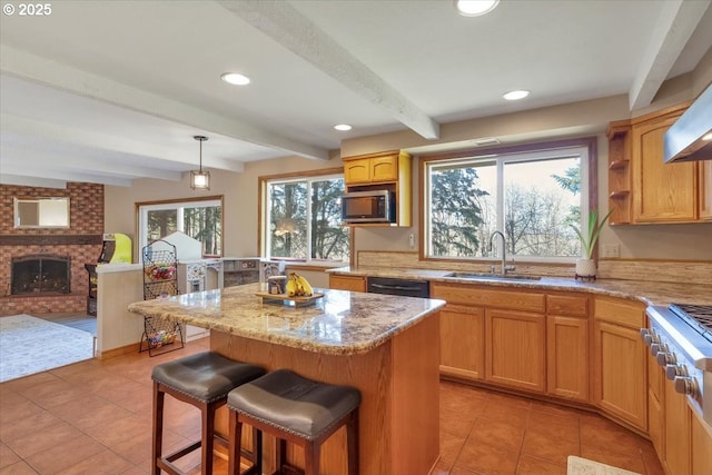 kitchen with light tile patterned floors, a kitchen bar, a sink, and stainless steel microwave