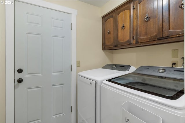 laundry area featuring washing machine and dryer and cabinet space