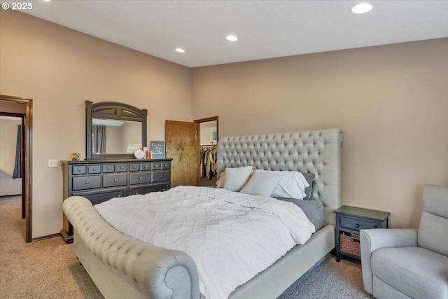 bedroom featuring baseboards, recessed lighting, a spacious closet, and light carpet