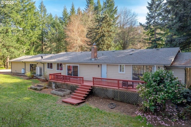 rear view of house with central air condition unit, a lawn, a chimney, and a wooden deck