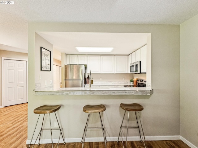 9908 SE Talbert St, Clackamas, OR 97015 - kitchen featuring stainless steel appliances, a peninsula, and white cabinets