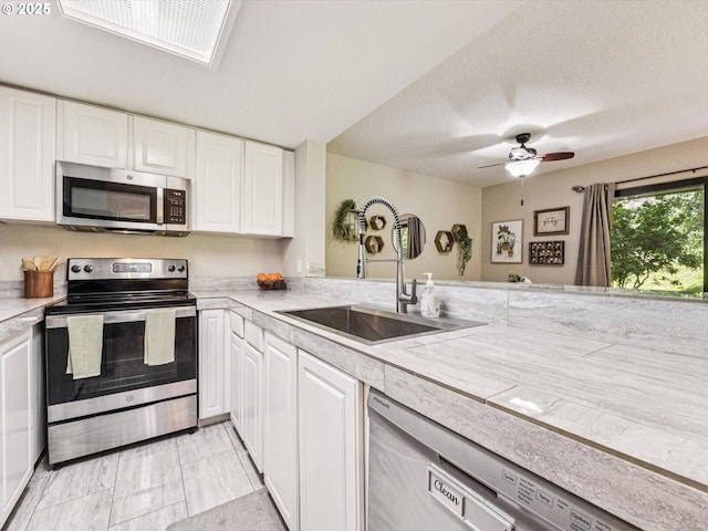 9908 SE Talbert St, Clackamas, OR 97015 - kitchen featuring appliances with stainless steel finishes, light countertops, white cabinets, a ceiling fan, and a textured ceiling