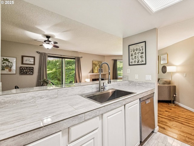 9908 SE Talbert St, Clackamas, OR 97015 - kitchen with stainless steel dishwasher, light countertops, white cabinetry, and ceiling fan