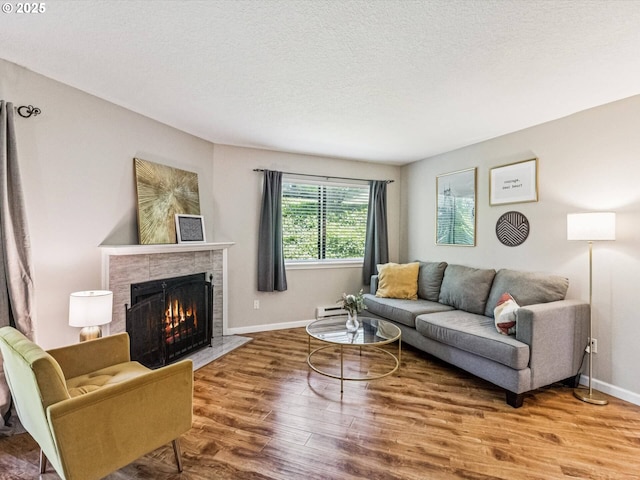 9908 SE Talbert St, Clackamas, OR 97015 - living area with wood finished floors, a fireplace, a textured ceiling, and baseboard heating