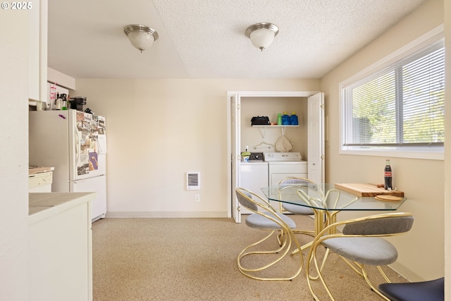 dining area featuring separate washer and dryer, a textured ceiling, and baseboards