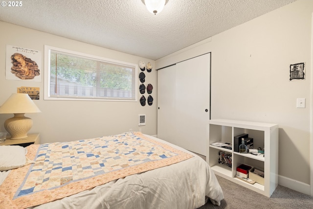 bedroom featuring a textured ceiling, carpet flooring, and a closet