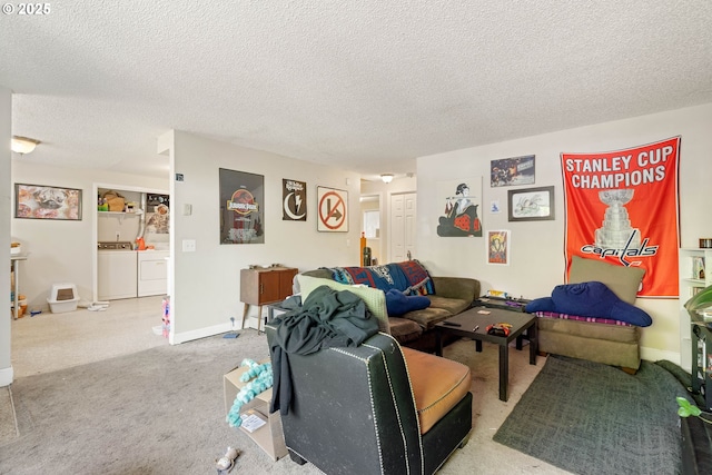 carpeted living room featuring a textured ceiling, washing machine and clothes dryer, and baseboards