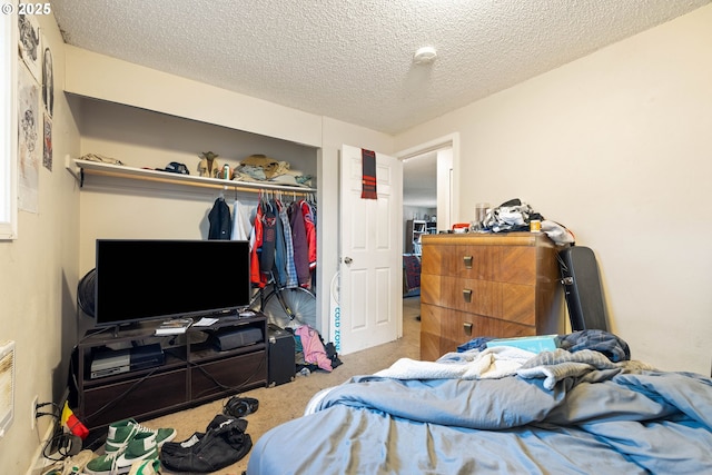carpeted bedroom featuring a textured ceiling and a closet