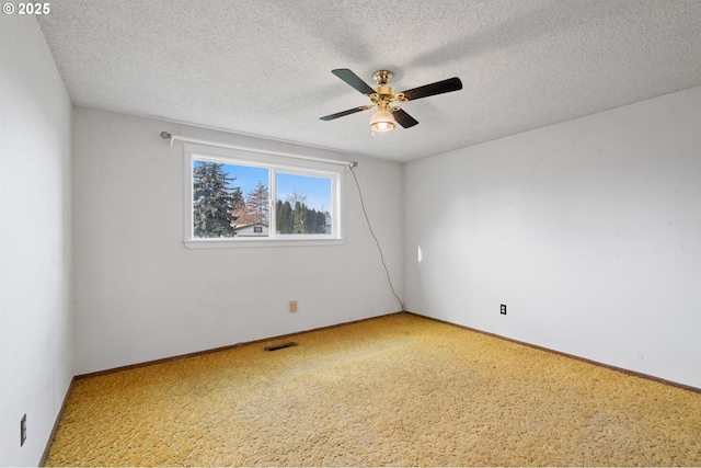 empty room with ceiling fan and a textured ceiling