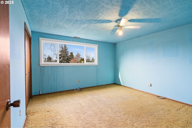 empty room with a textured ceiling and ceiling fan