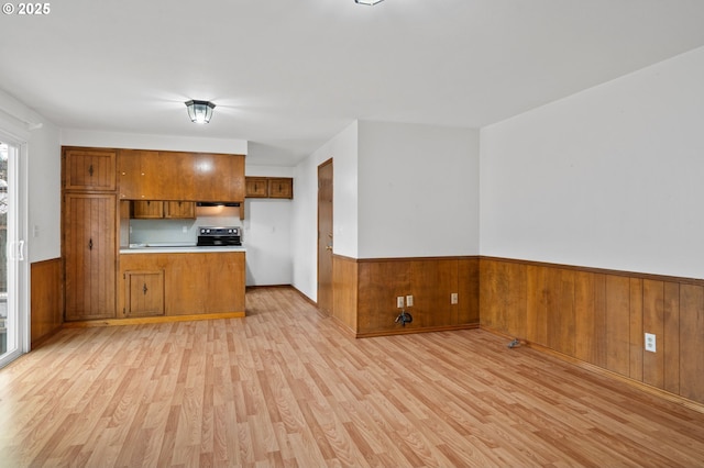 kitchen featuring range with electric cooktop, range hood, light hardwood / wood-style flooring, and kitchen peninsula