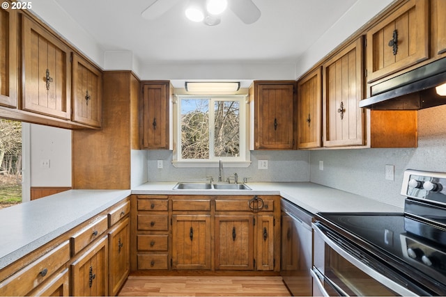 kitchen featuring sink, ceiling fan, appliances with stainless steel finishes, decorative backsplash, and light wood-type flooring