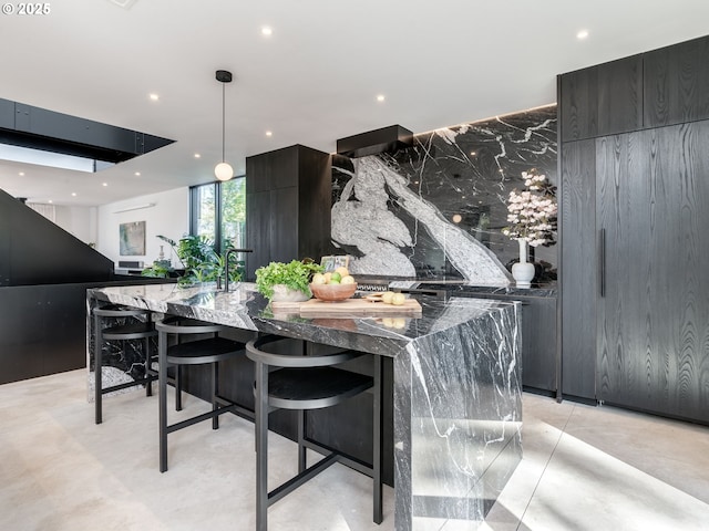 kitchen with recessed lighting, modern cabinets, dark stone counters, hanging light fixtures, and a spacious island