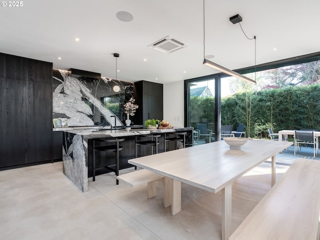dining space with a wall of windows, concrete floors, and recessed lighting
