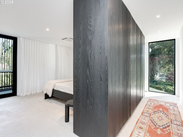 corridor featuring expansive windows, concrete flooring, and recessed lighting