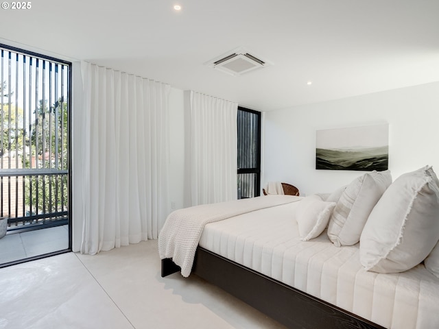 bedroom featuring access to outside, finished concrete floors, and recessed lighting