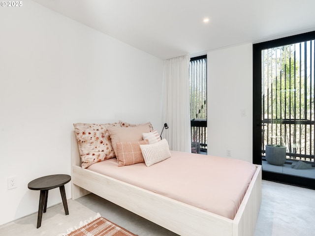 bedroom featuring access to exterior, multiple windows, and light colored carpet
