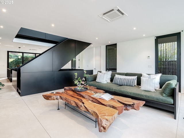 living room with recessed lighting and finished concrete flooring