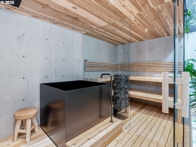 relaxing sauna with hardwood / wood-style flooring and wood ceiling
