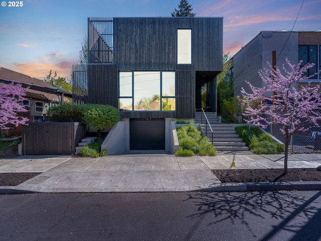 modern home featuring stairway, an attached garage, and concrete driveway