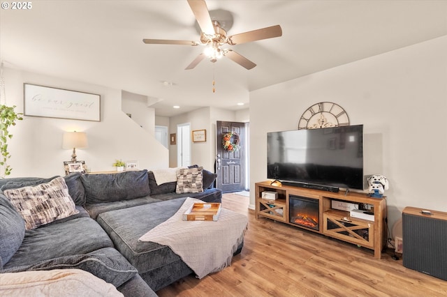 living room featuring ceiling fan and light hardwood / wood-style flooring