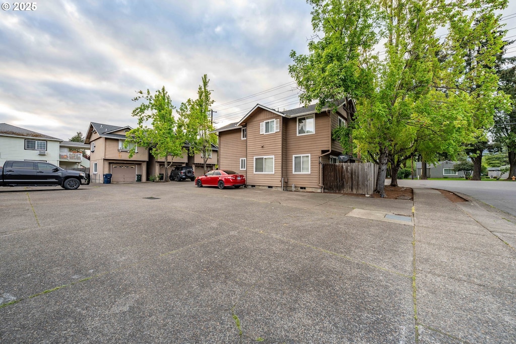 view of front of house with uncovered parking, fence, and a residential view