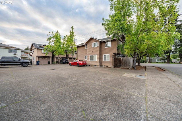 view of front of house with uncovered parking, fence, and a residential view