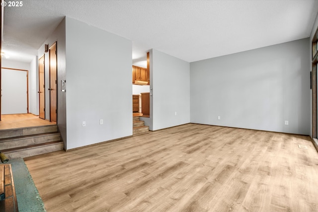 empty room with light wood-type flooring and stairway