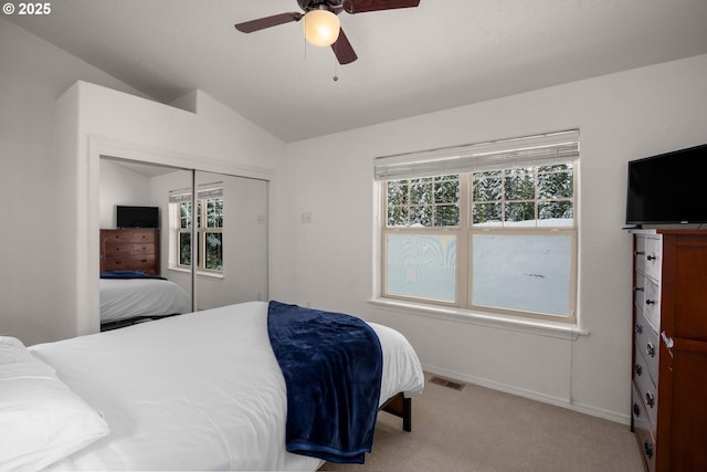 carpeted bedroom with visible vents, baseboards, lofted ceiling, and multiple windows