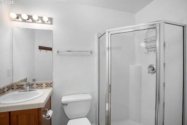 full bathroom with vanity, backsplash, a stall shower, and toilet