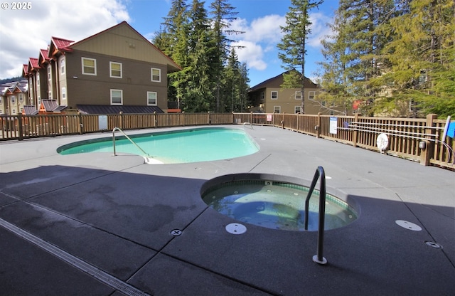 pool featuring a patio, a community hot tub, and fence