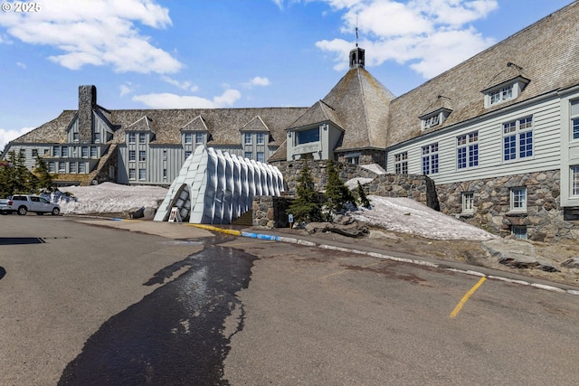 view of front of home with a chimney and stone siding