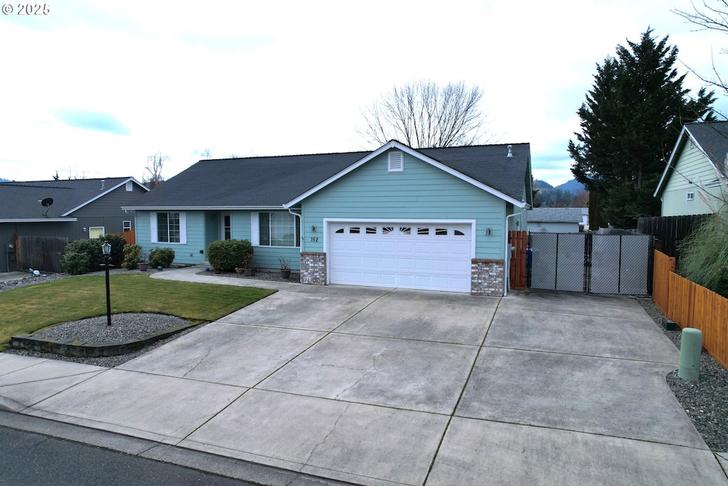 ranch-style home with a garage and a front lawn