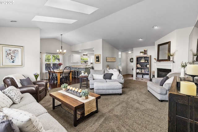 1537 W 13th Ave, Junction City, OR 97448 - carpeted living area with vaulted ceiling, a chandelier, a glass covered fireplace, and a skylight