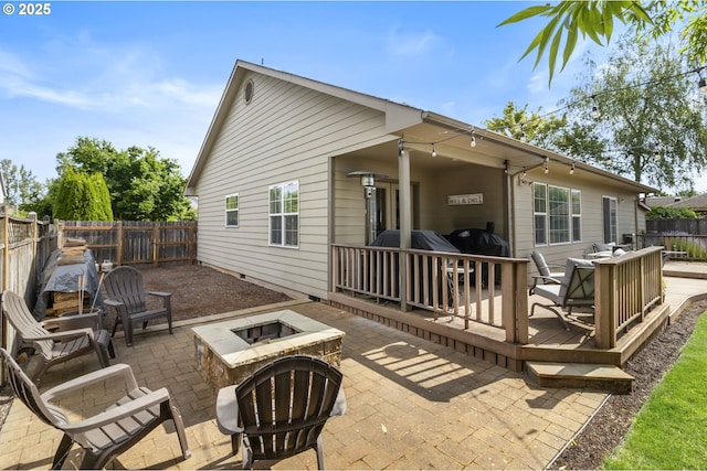 1537 W 13th Ave, Junction City, OR 97448 - back of property featuring a fire pit, a fenced backyard, a wooden deck, and a patio area