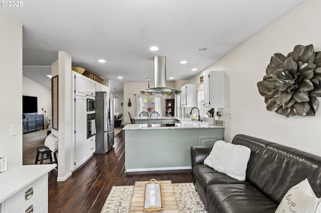 1537 W 13th Ave, Junction City, OR 97448 - kitchen with island range hood, appliances with stainless steel finishes, a peninsula, white cabinetry, and dark wood-type flooring