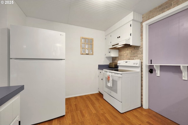 kitchen featuring white appliances, white cabinets, under cabinet range hood, dark countertops, and light wood-type flooring