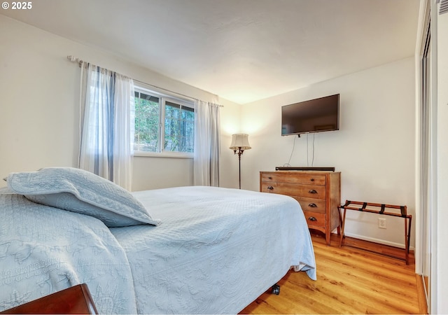 bedroom with baseboards and light wood-type flooring