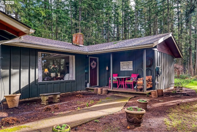 view of front of property featuring a porch, board and batten siding, and a chimney