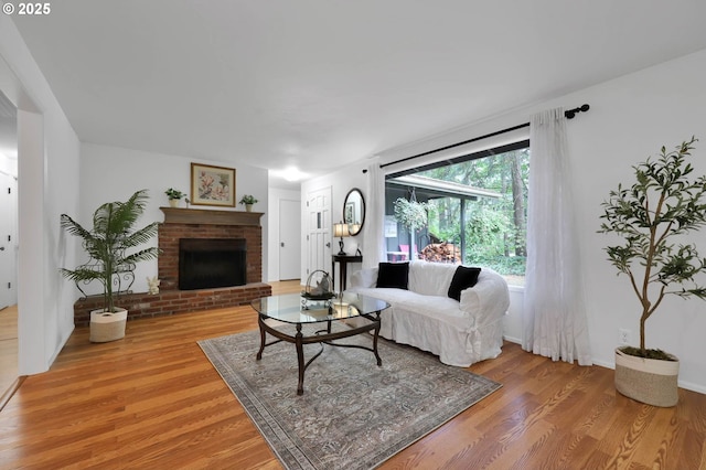 living area with a brick fireplace and light wood-type flooring