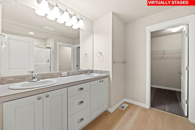 bathroom with wood-type flooring, vanity, and an enclosed shower