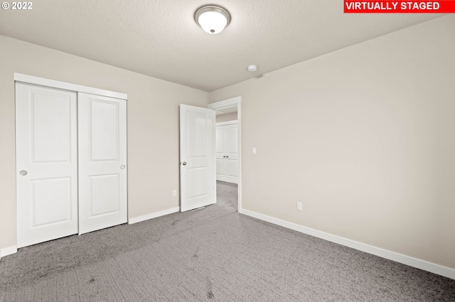 unfurnished bedroom featuring a textured ceiling and a closet