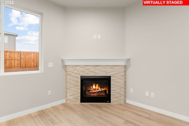 interior details featuring hardwood / wood-style flooring and a tiled fireplace